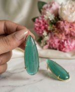 Natural green stone brass earrings featuring elongated teardrop stones in a gold-tone setting.