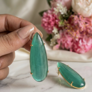 Natural green stone brass earrings featuring elongated teardrop stones in a gold-tone setting.